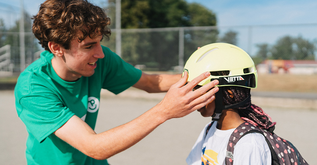 pedalheads-instructor-checking-helmet-fit-on-camper