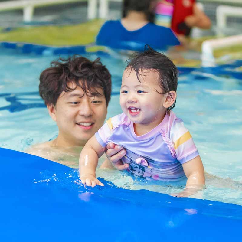 Father swimming with kid