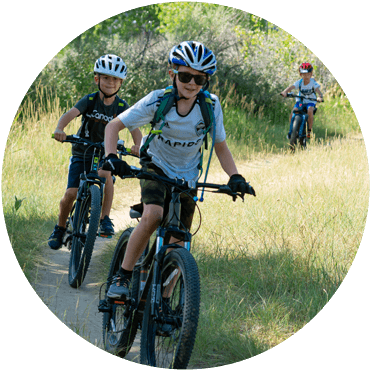 Kids smiling while riding a trail
